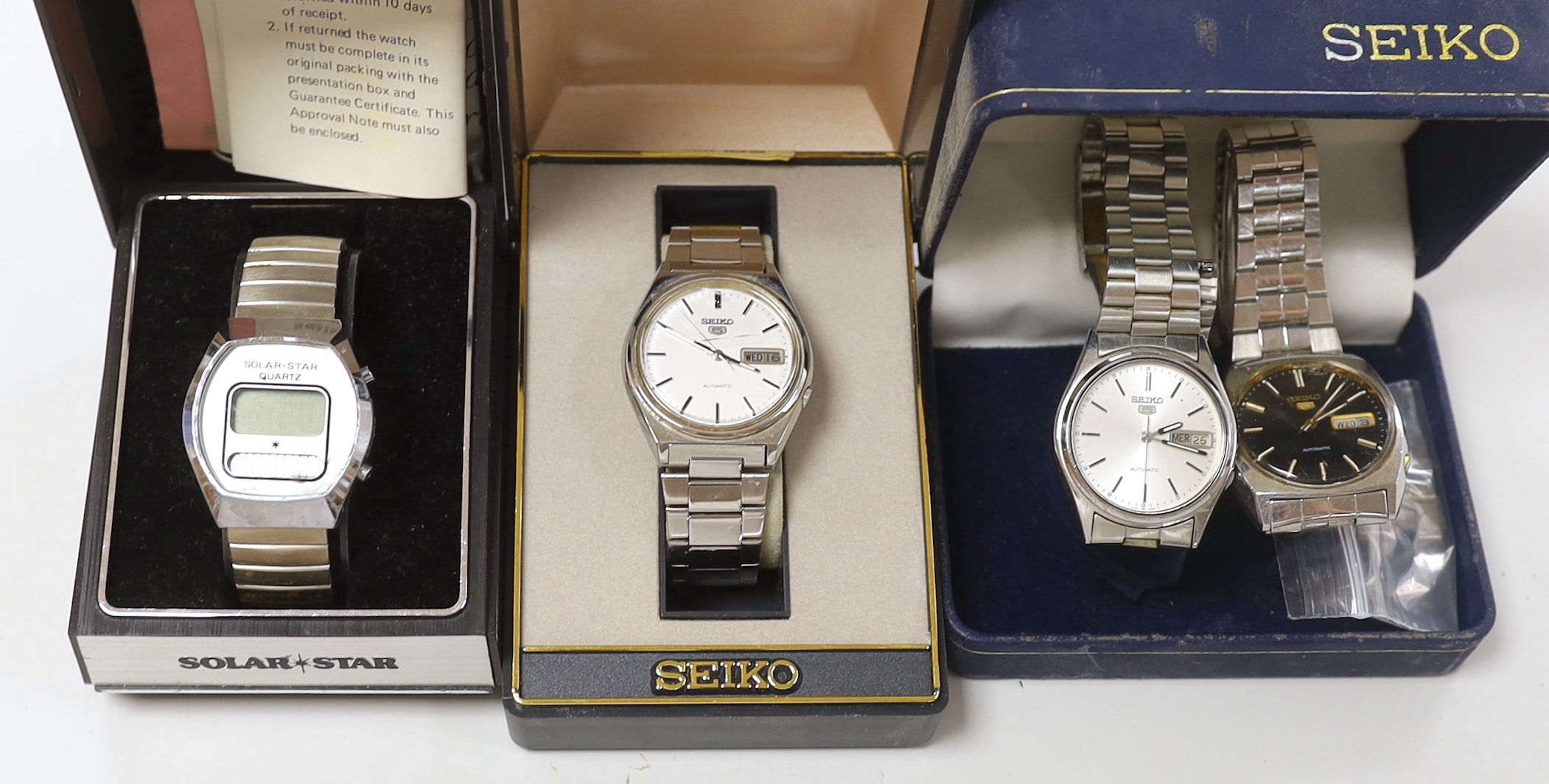 Three gentleman's stainless steel Seiko 5 automatic wrist watches including one with black dial and a Solar Star quartz wrist watch.